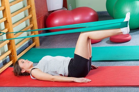 Girl stretching legs with elastic band